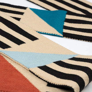 Colorful geometric-patterned scarf with black, beige, blue, and red triangles on a white background