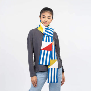 Person wearing a colorful geometric-patterned scarf on a plain background