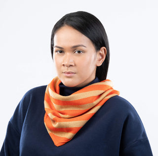 Woman wearing an orange and beige striped scarf on a white background