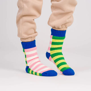 Colorful striped socks worn with beige pants on a white background