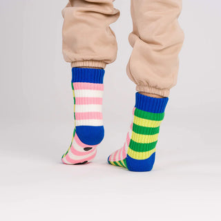 Colorful striped socks worn with beige pants on a light gray background