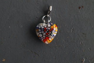 Millefiori patterned heart shaped pendant on a gray textured surface