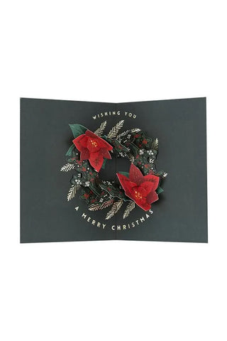 Christmas card with a wreath design and red flowers on a black background