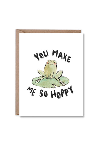 greeting card with a brown kraft envelope, featuring a watercolor-style frog sitting on a lily pad with the text 'YOU MAKE ME SO HOPPY' 