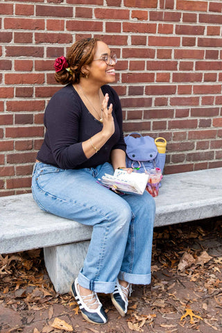 Woman sitting on a bench with a brick wall background