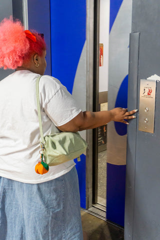 Person with a colorful hair getting on an elevator