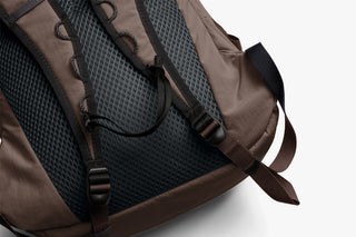 Brown backpack with black mesh back panel on a white background