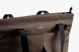 Brown bag with black straps and 'bellroy' branding on a white background