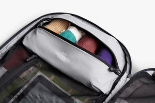 Gray backpack with a packing compartment with colorful socks inside