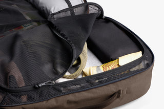 Close-up of travel pack with clothes and a map inside, on a white background