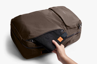 Brown travel bag with a hand opening side compartment on a white background