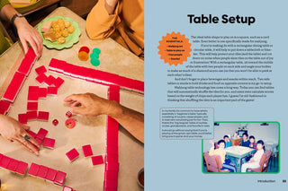 Hands playing with red mahjong pieces on a table with text about table setup.