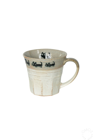 Beige ceramic mug with a cat parade design on a white background