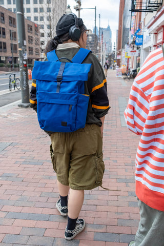 Person wearing a blue backpack on a city street