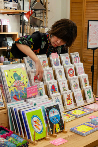 Naoshi adjusting the display of sand art kits