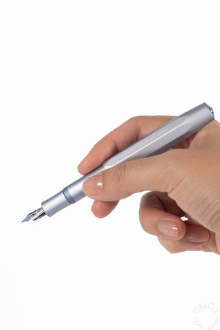 A hand holding a blue metallic fountain pen on a white background.