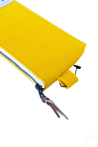Close-up of zipper and loop on Luddite bright yellow pen case on a white background 