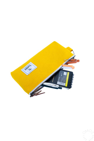 Luddite bright yellow pen case with pens and a notebook inside on a white background 