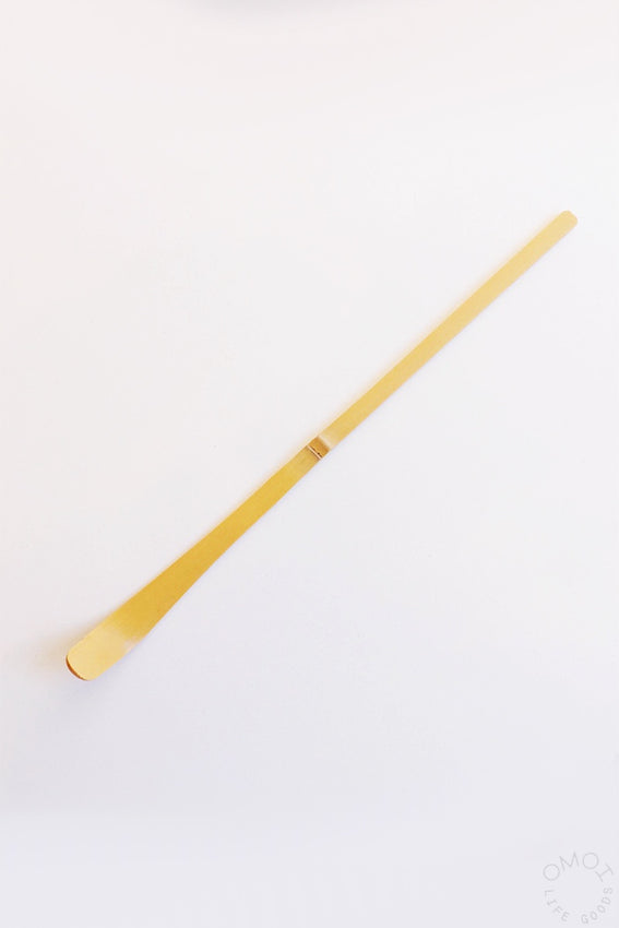 Wooden matcha chashaku scoop on a white background