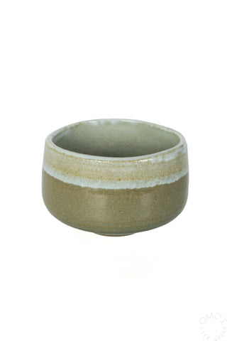 Above angle view of olive and sage green ceramic bowl matcha chawan on a white background