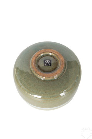 Bottom of olive green ceramic matcha chawan bowl on a white background