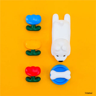 White dog-shaped toy on a yellow background