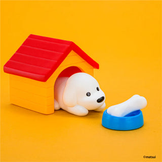 Toy dog with a red roofed house and blue bowl on an orange background