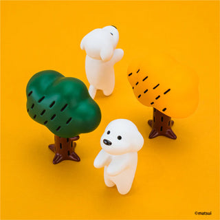 Two white dog figurines and two tree-shaped stands on an orange background