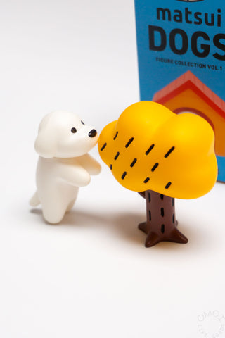 Small white dog figurine interacting with a yellow tree against a white background