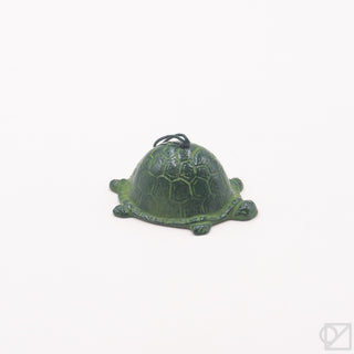 Green turtle-shaped wind chime on a white background