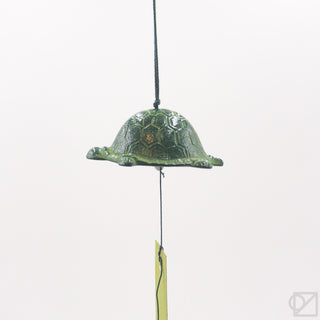 Green turtle-shaped wind chime on a white background