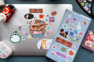 Collection of colorful stickers on a laptop and a planner with more stickers