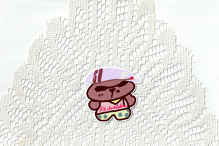 Bear sticker with pink and yellow hat on a white lace background