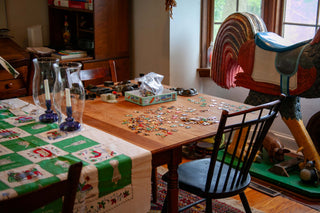 The dining room table with a puzzle in progress and antique family heirlooms all around.