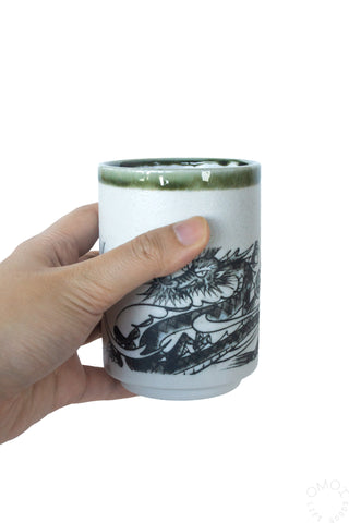 Ink dragon teacup with dragon illustration and green glaze rim on ceramic cup