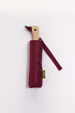 Maroon umbrella with wooden handle on a white background