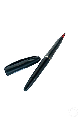 Red ink marker with pointed tip and black body.