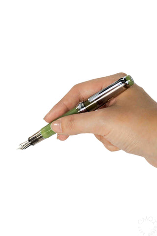 Hand holding a Sailor green pen with a white background