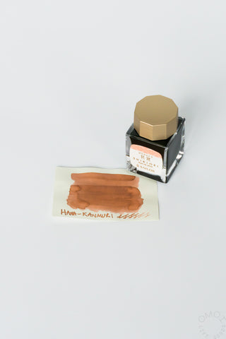 Sailor ink bottle with light ta swatch on a white background