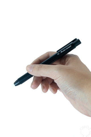 Mechanical eraser pen held in hand, black body with eraser tip