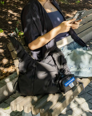Black Topologie Cloud hobo bag with drawstring closure and front pouch labeled HAPPIER