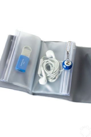 Opened black holographic 5 pocket pouch with items inside pockets on a white background