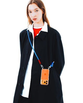 Person wearing a black coat with a phone case on a blue strap against a white background