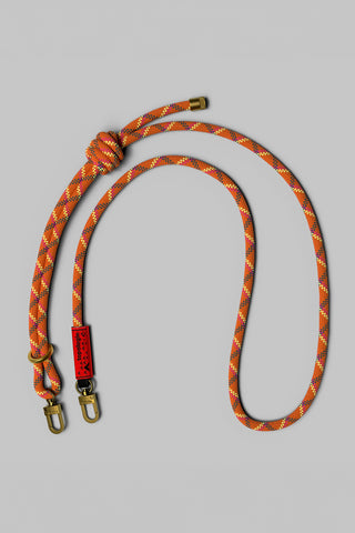 Orange and red rope with metal clips on a gray background