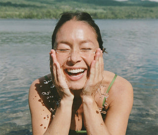 Person with their hands against their face in a body of water
