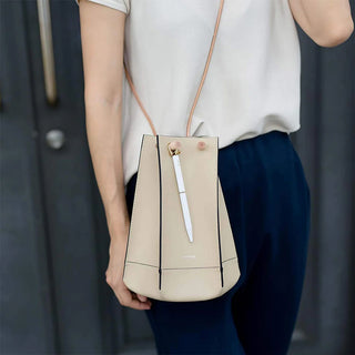 White ystudio pen on a beige bag carried by a person